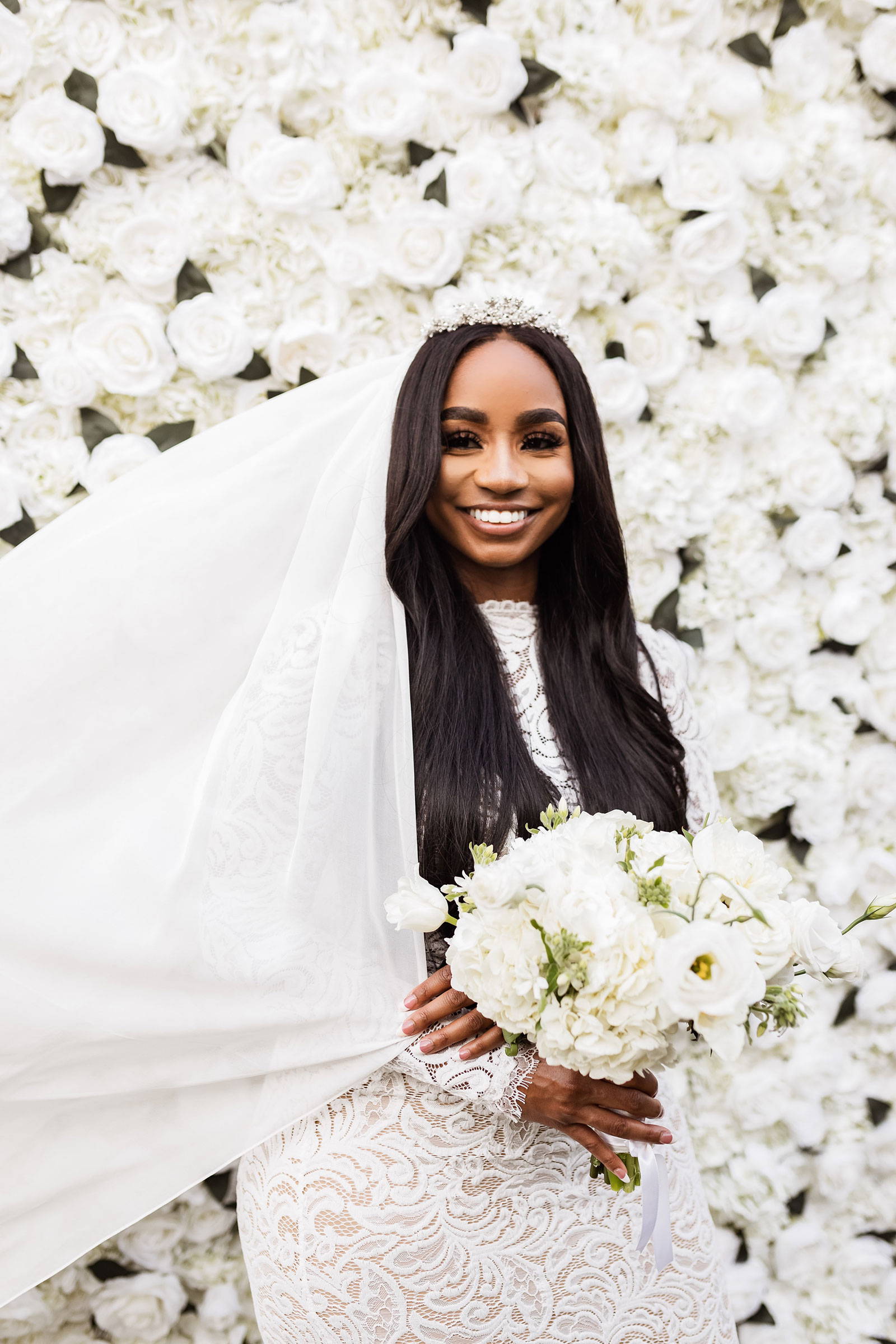 Bride in lace dress holding white flowers 