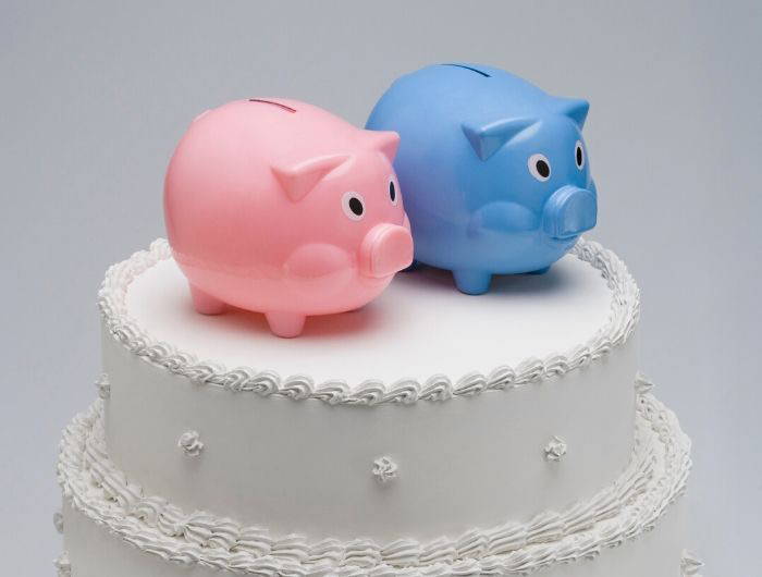 Pink and blue piggy banks on top of a wedding cake