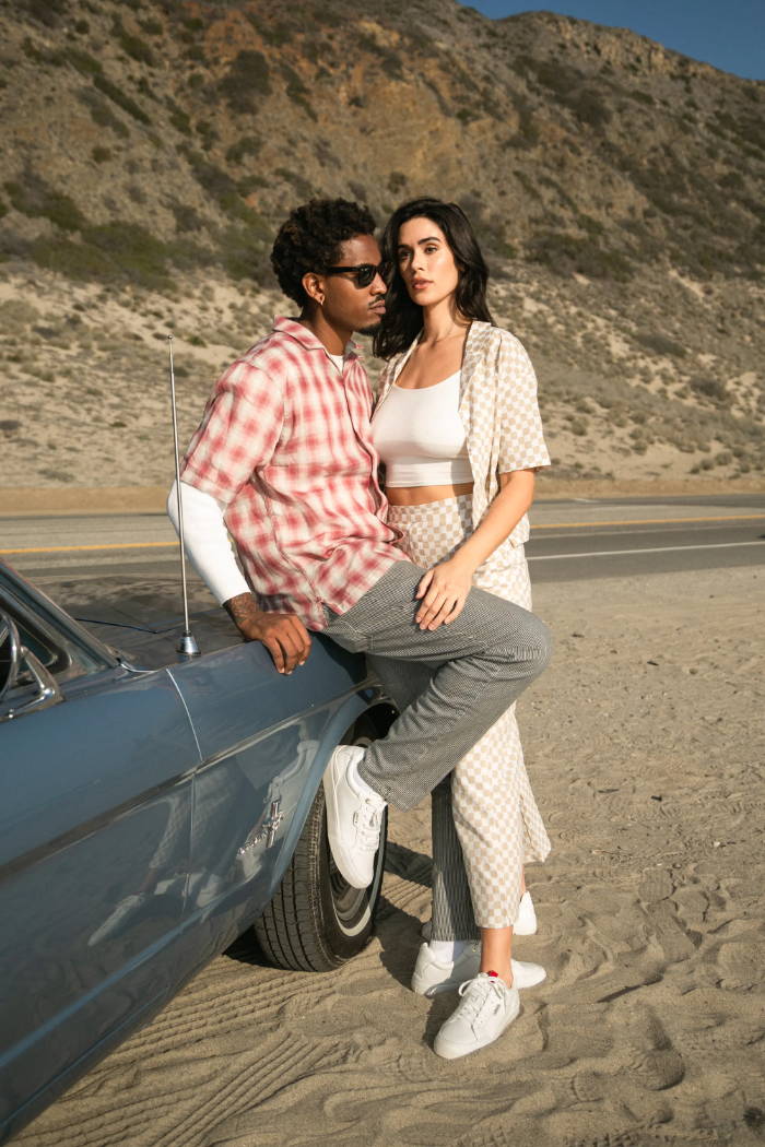 Male and Femail Models leaning on car by the beach wearing Levi's 521 XX  EST Lo  Leather Sneakers 