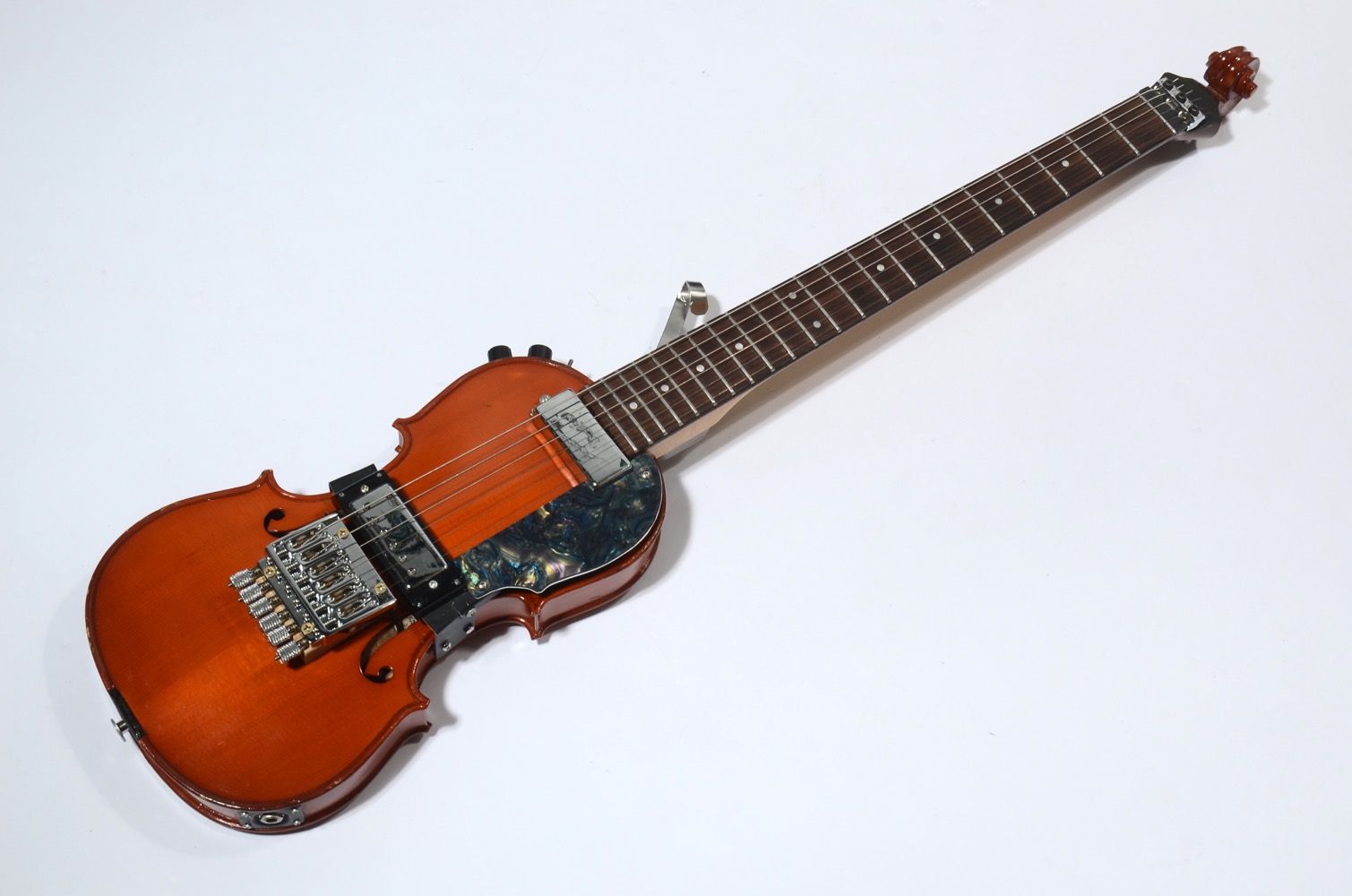 A wooden electric violin with a unique design and metal components.