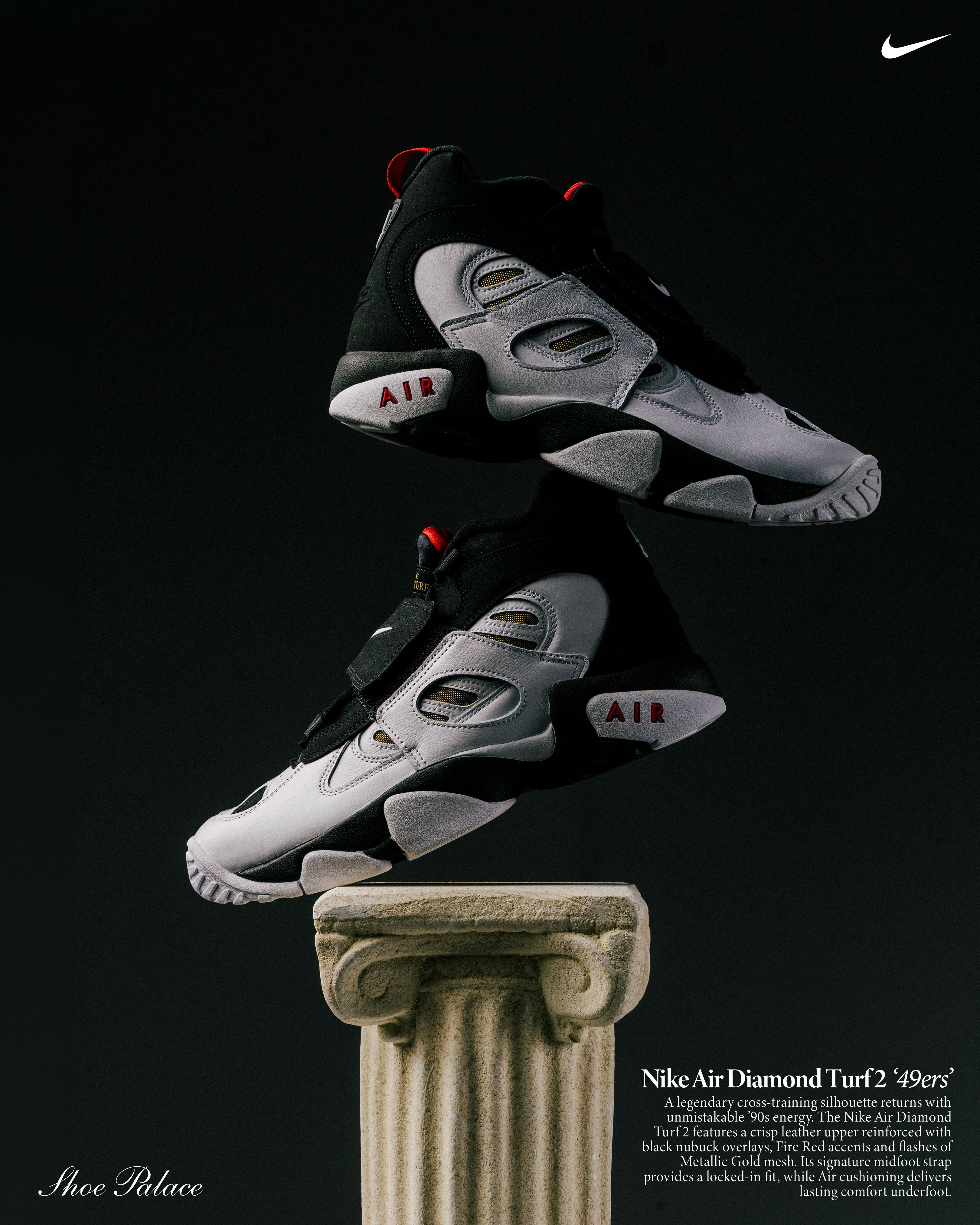 Nike Air Diamond Turf 2 sneakers displayed on a column against a dark background.