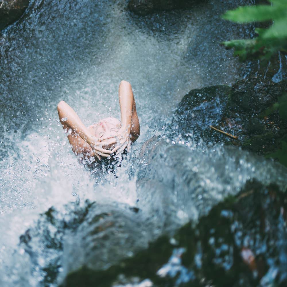 Women in waterfall feeling refreshed as if she used Tension Meltaway