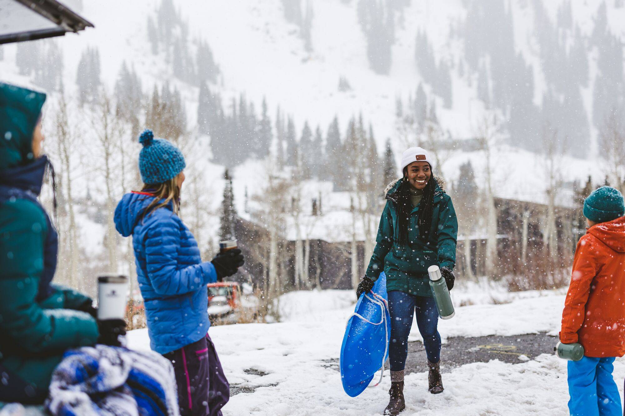 Group of friends at car with open trunk getting ready to sled