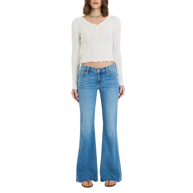 A person wearing a white crop top and blue flared jeans.