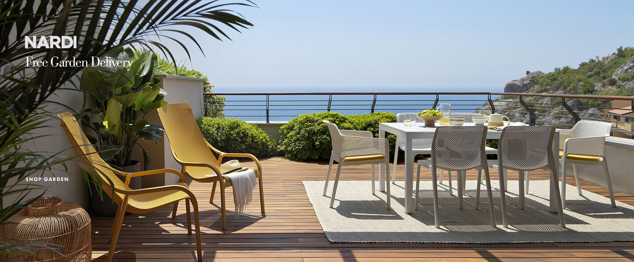 Beautiful sunny day with Nardi net lounge chairs in yellow on a balcony overlooking the Italian coast