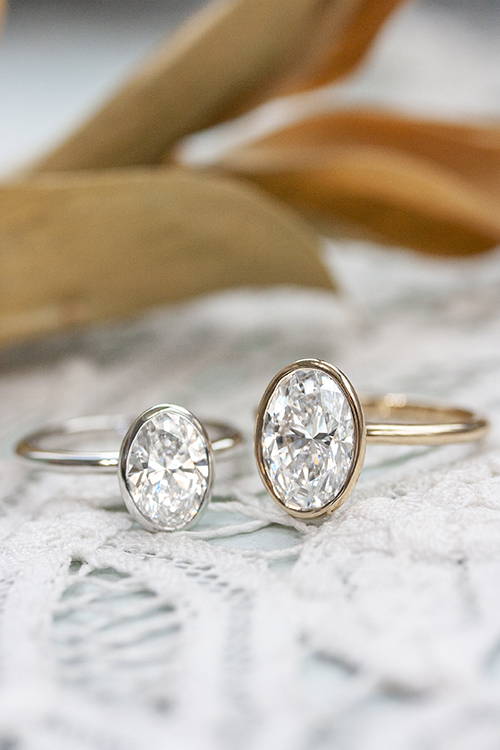 two bezel set oval engagement rings