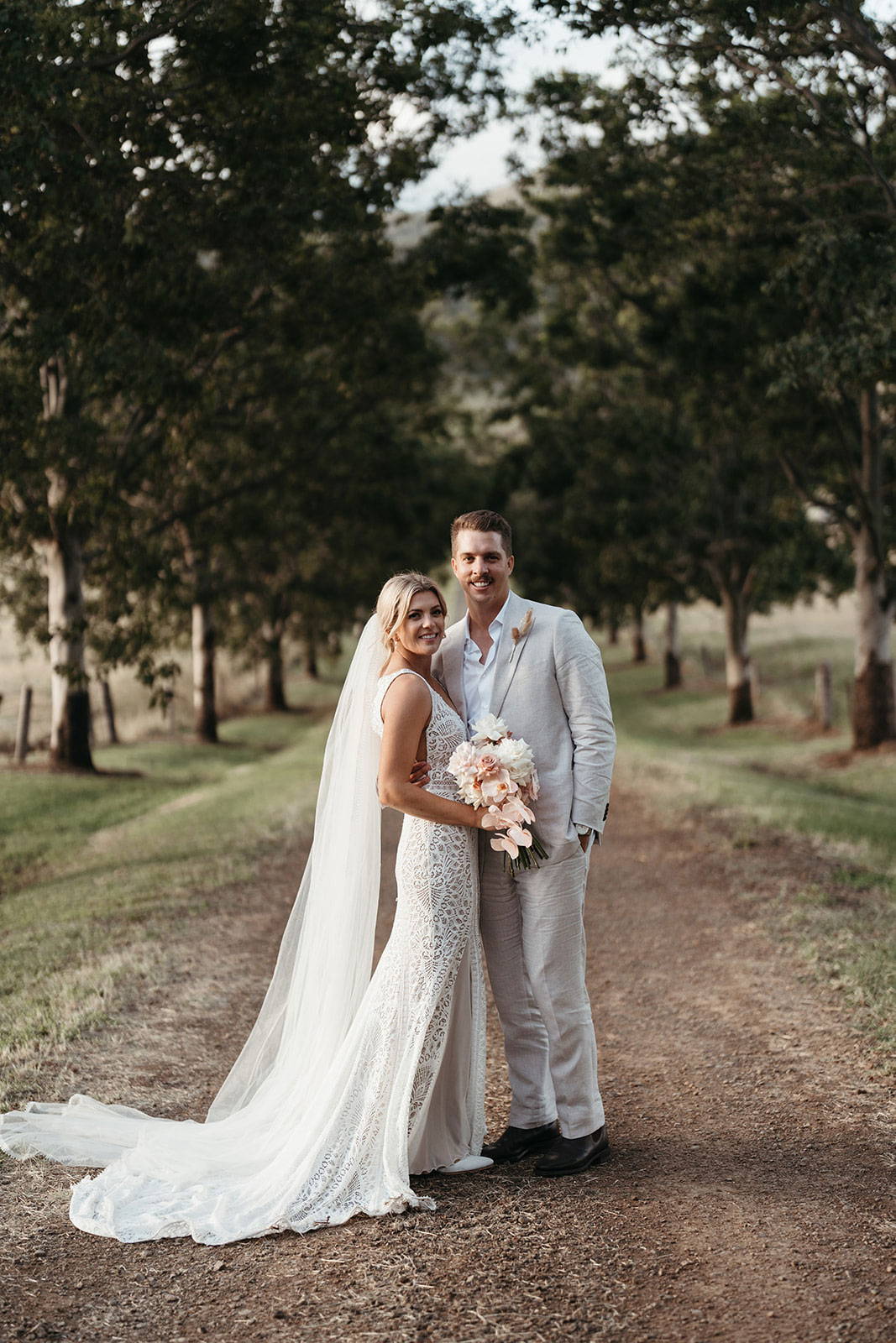 Bride and Groom posing amongst forest trees