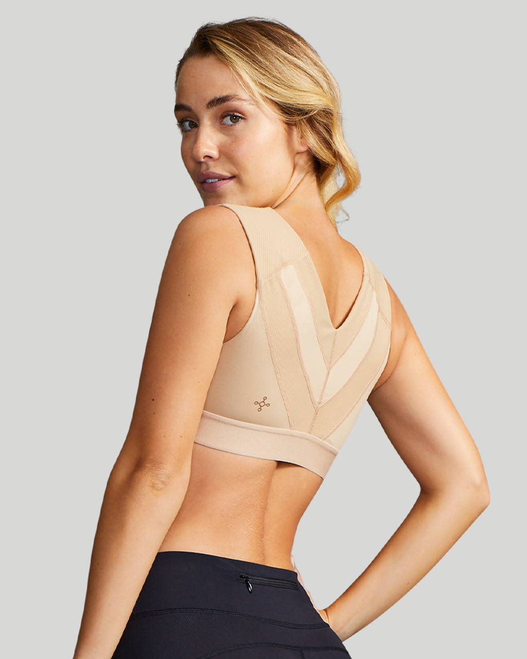 A woman wearing a natural Tommie Copper Shoulder Support Bra