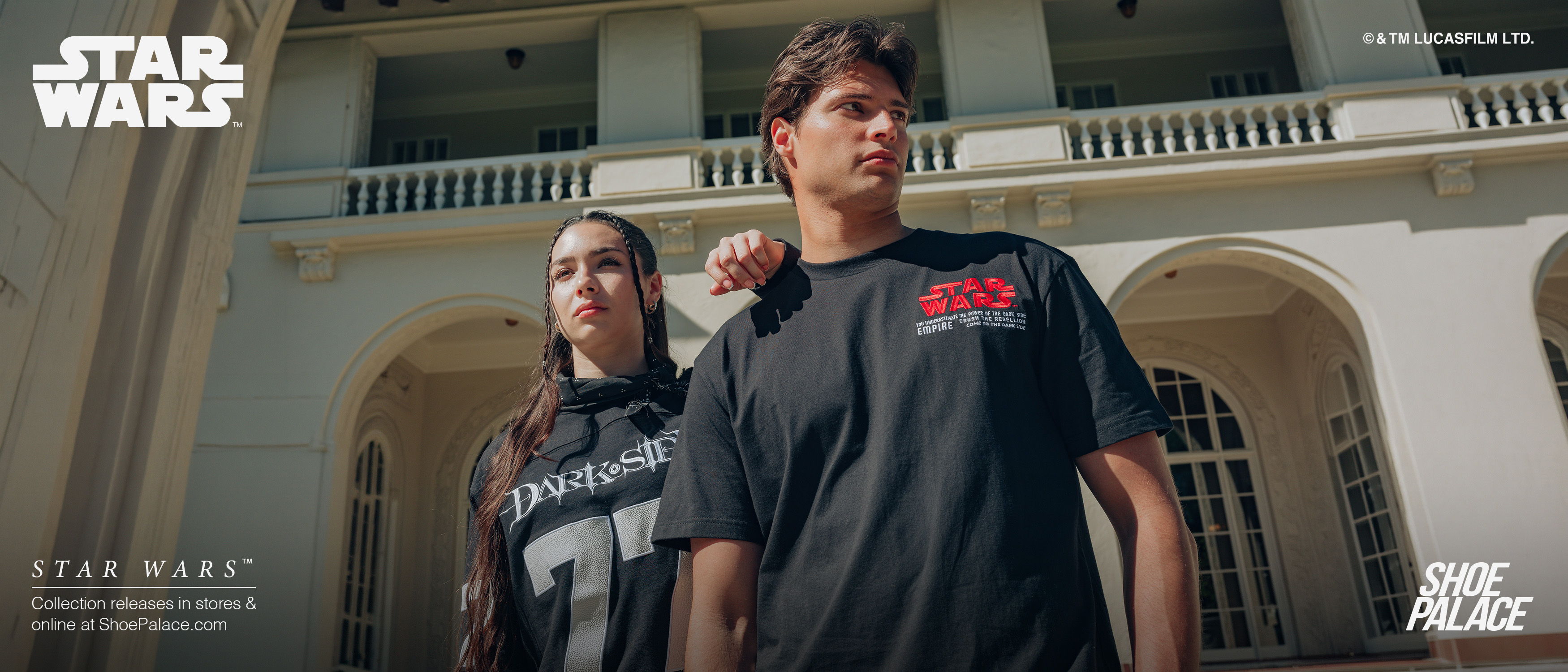 Two people in Star Wars-themed attire pose outside a building.
