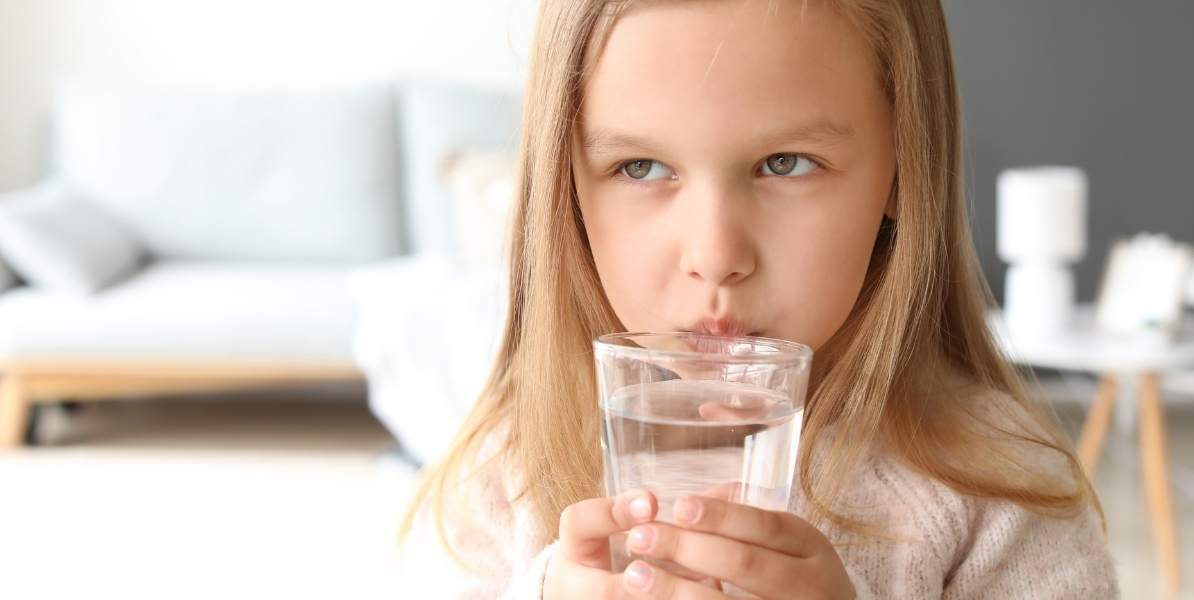 Niña bebiendo agua purificada por rayos UV