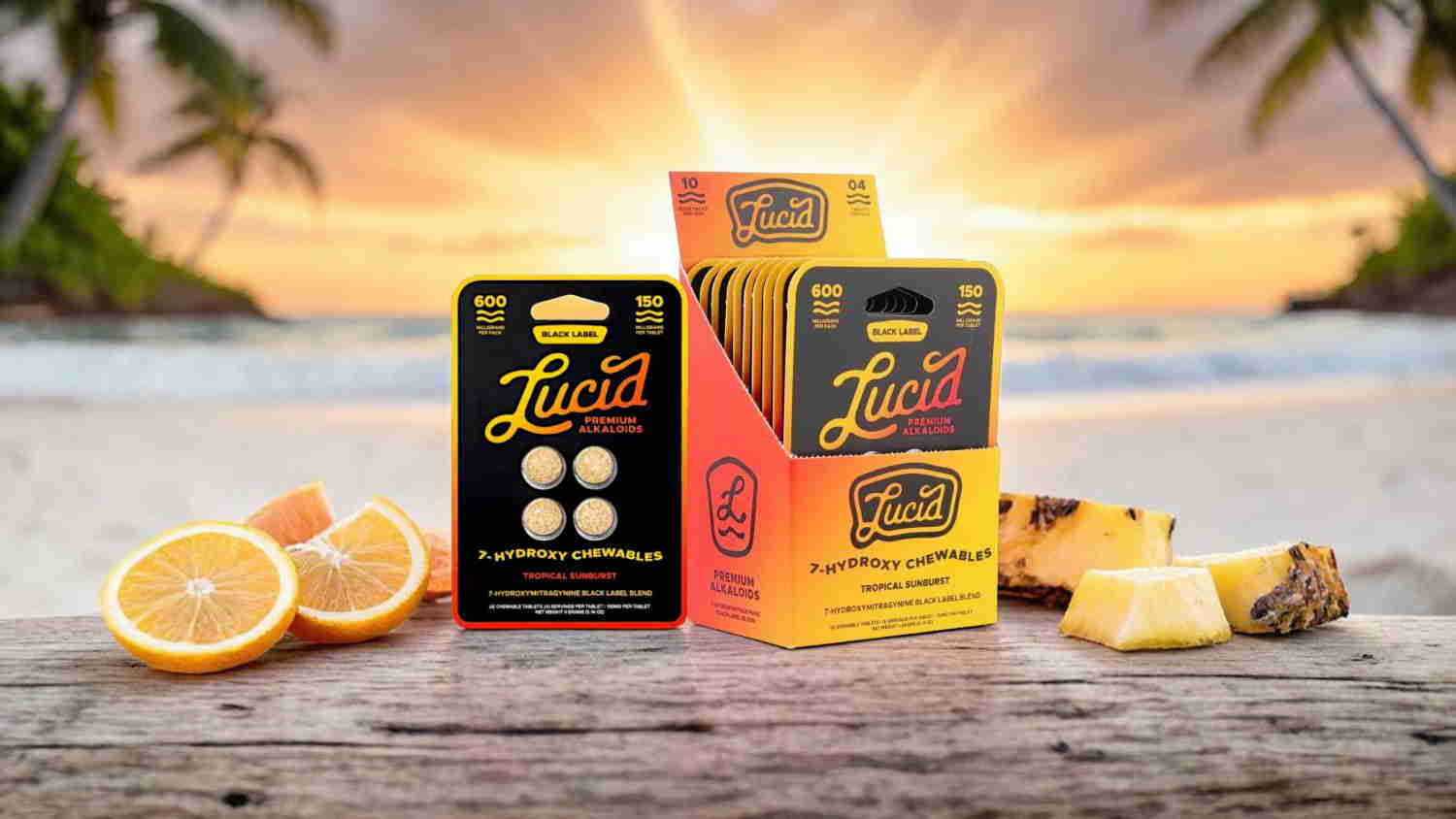 Two boxes of supplements with fruit on a beach at sunset.