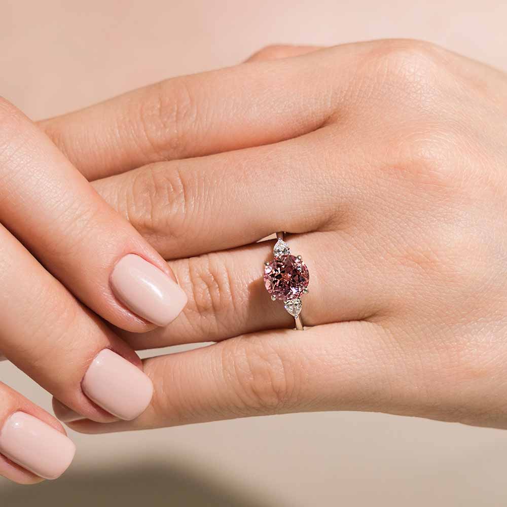 Elegant three stone engagement ring with 1ct round cut lab pink sapphire center stone