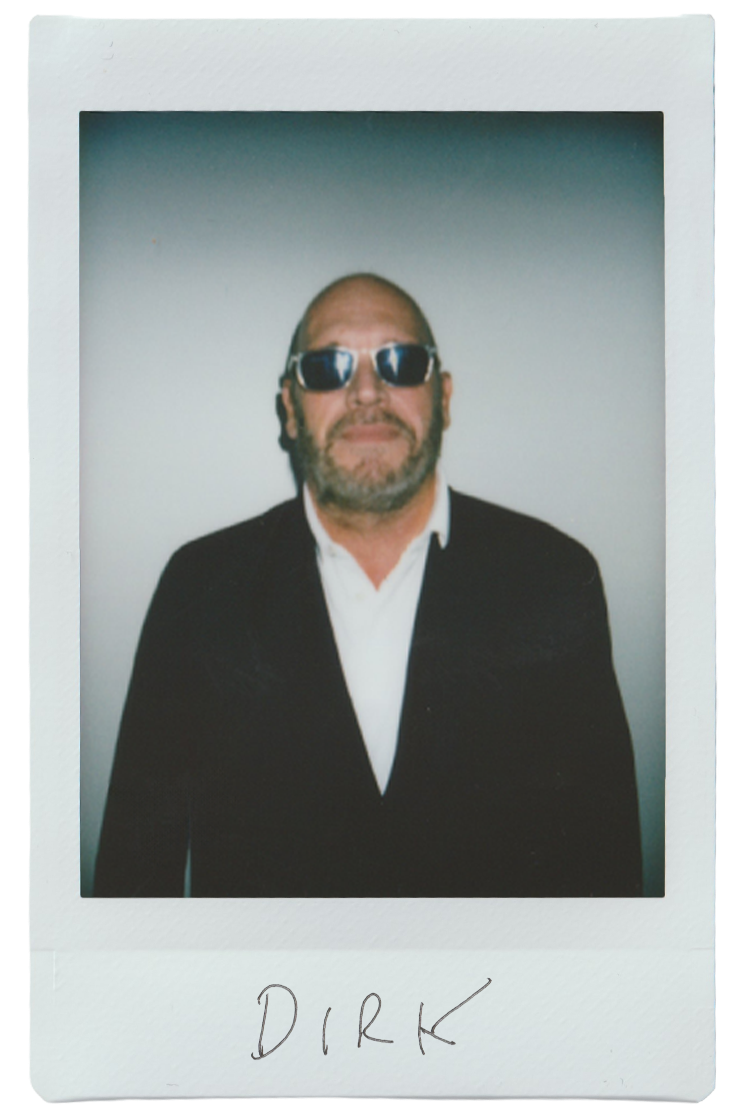 Man in sunglasses wearing a black suit, polaroid photo labeled 