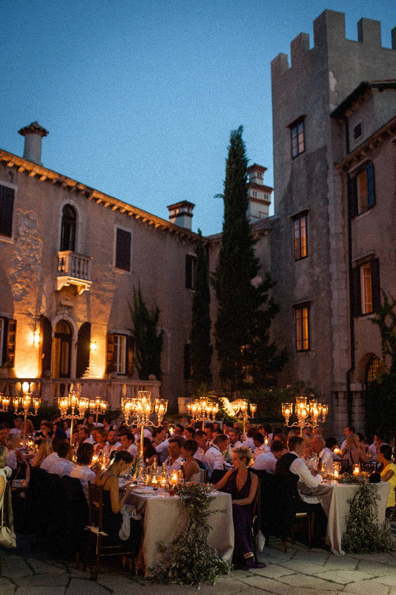 Italian patio with wedding guests sitting on a long table