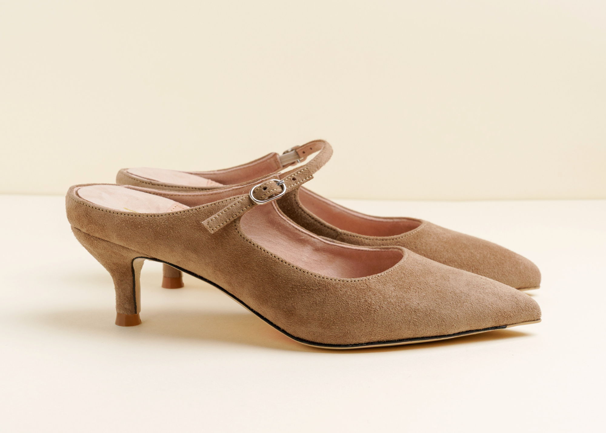 Brown suede slingback heels with a pointed toe and small heel.