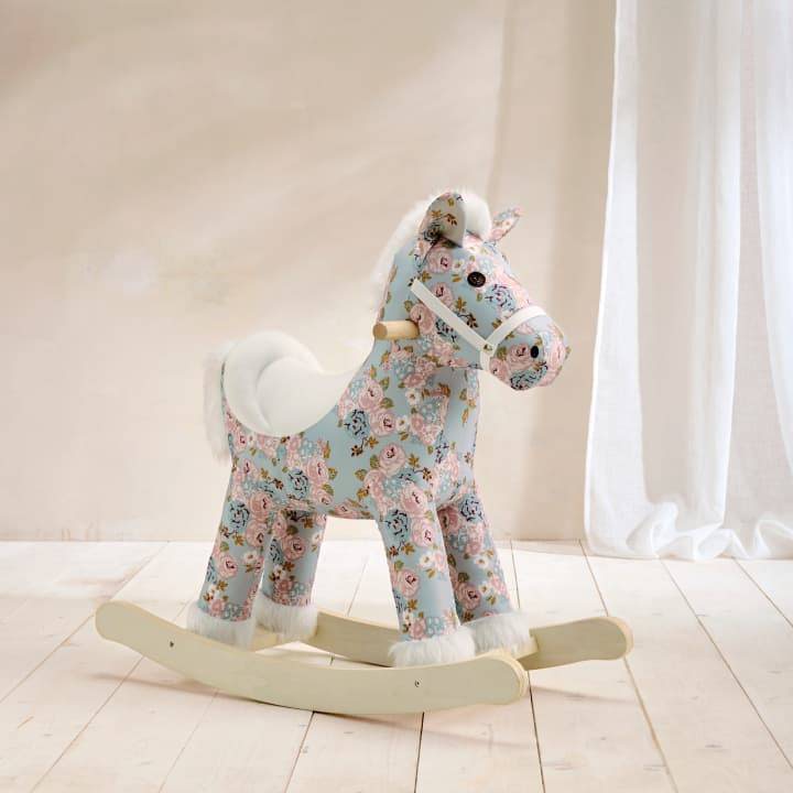 A floral rocking horse is pictured with a plain beige background.