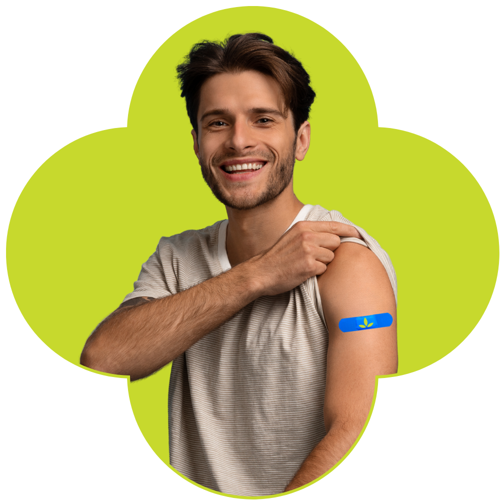Smiling man showing off flu vaccination bandage on his arm.
