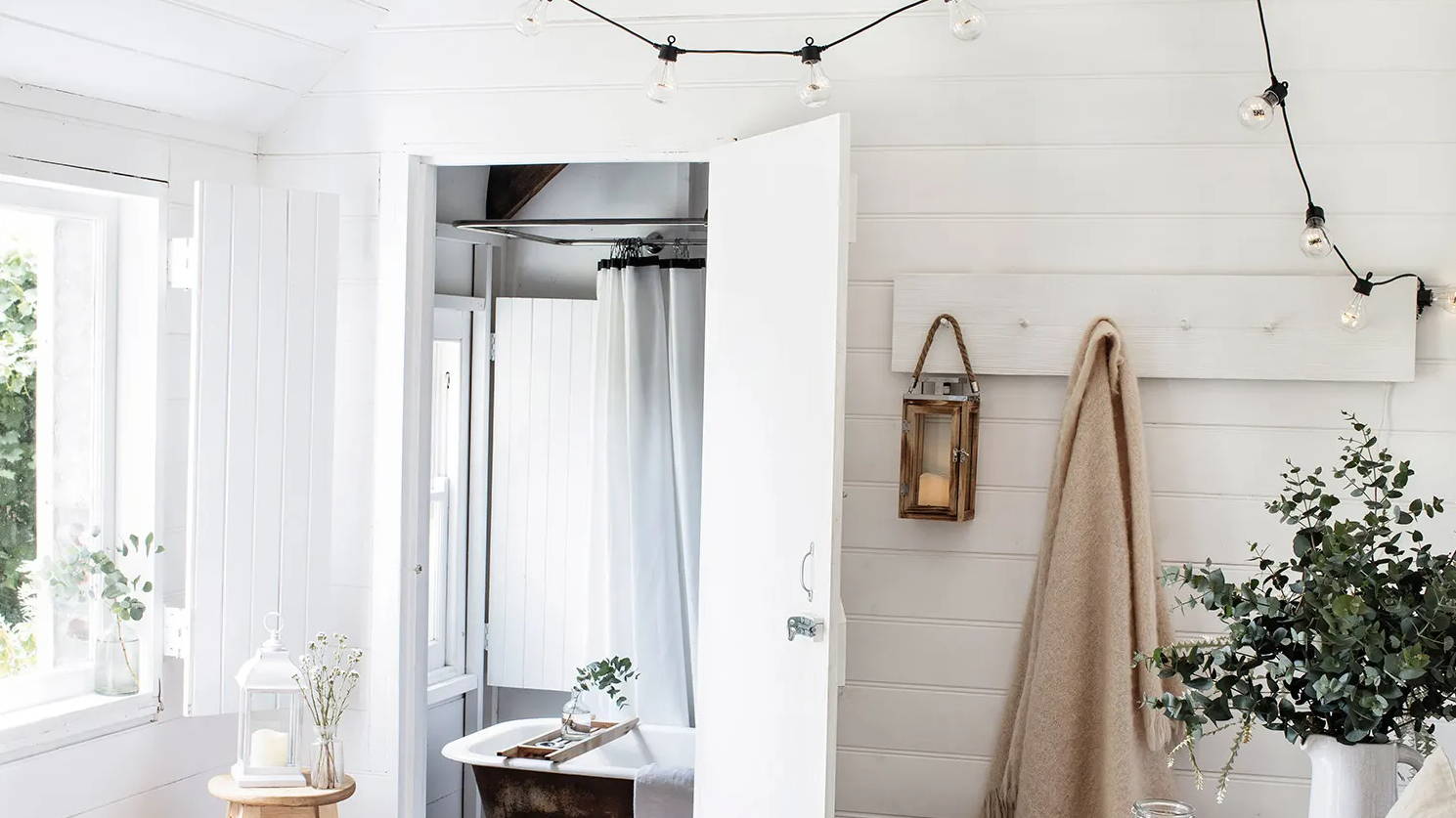 Bedroom with festoons hung from ceiling and indoor lanterns displayed with spring foliage 