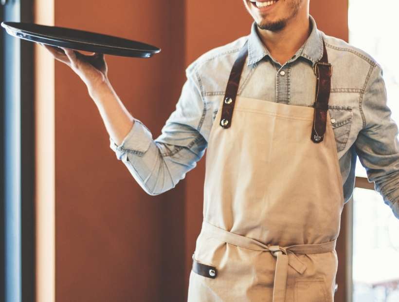 Waiter wearing a denim shirt and khaki apron