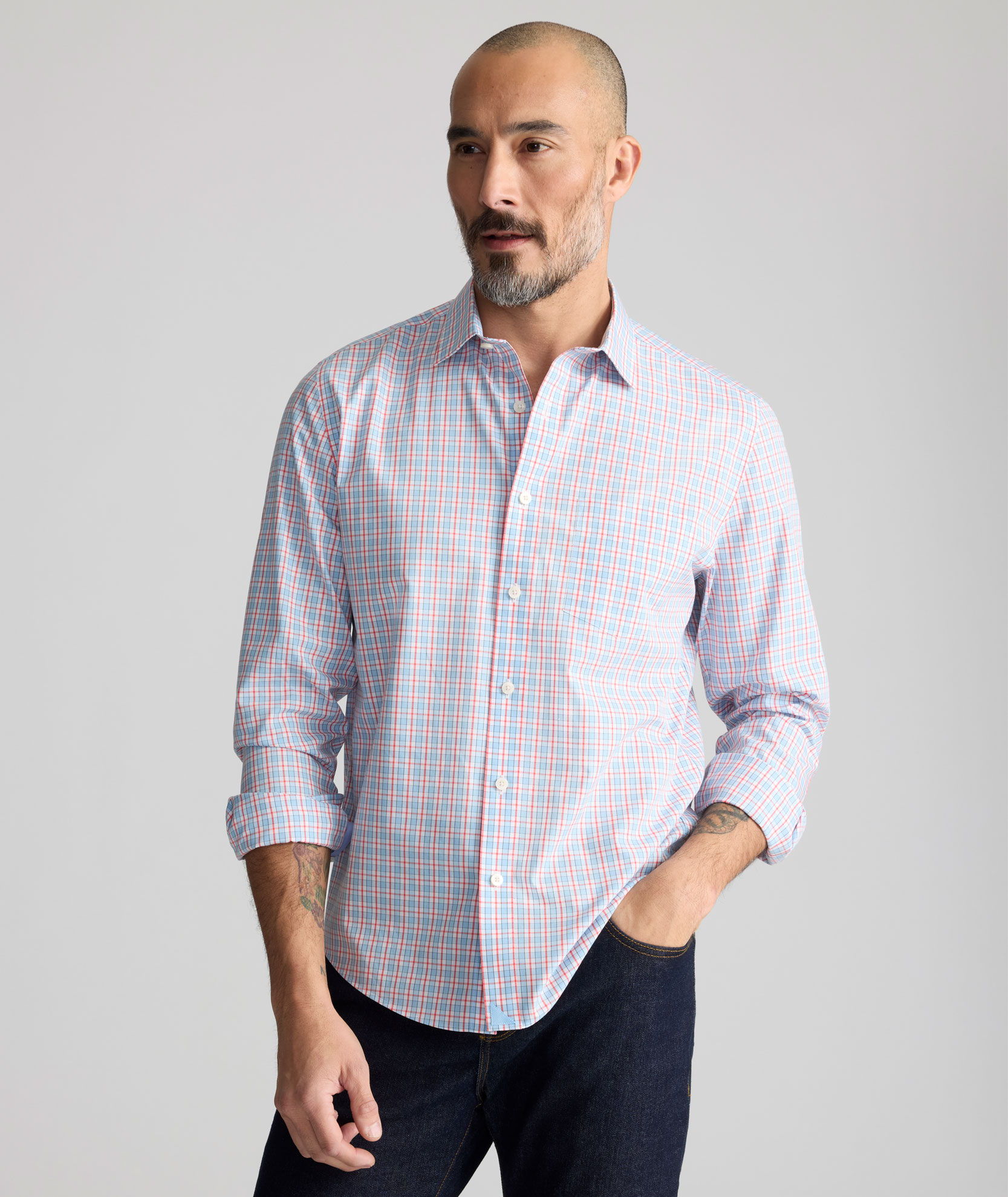 Man in a button-up shirt posing against a neutral background.