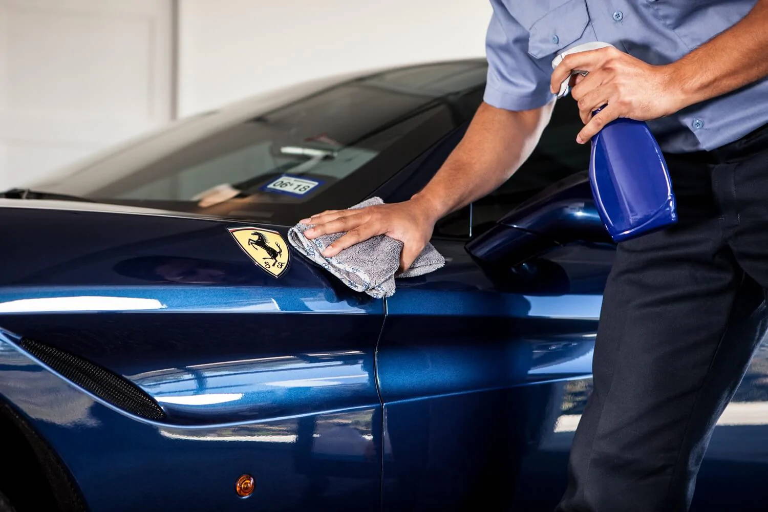 person wiping car with microfiber car towel