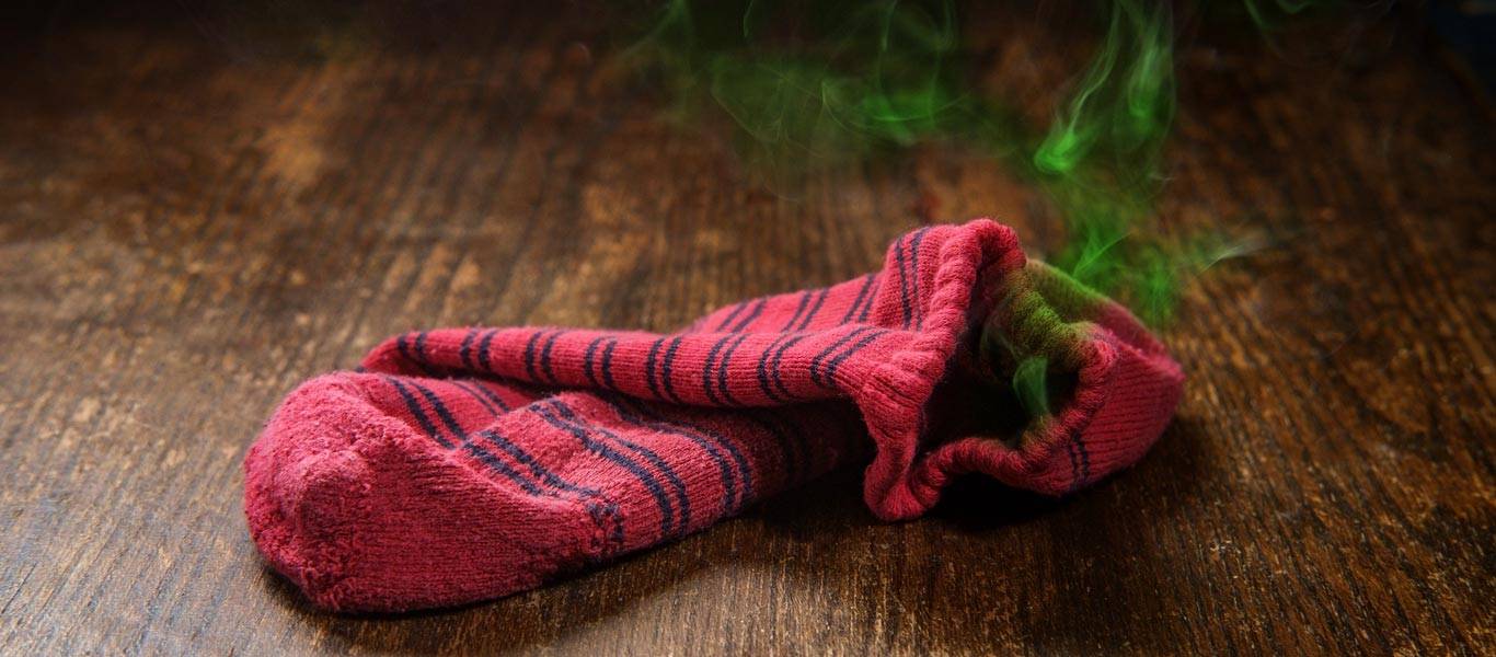 Smelly dirty laundry sock with colorful visible odor vapor illustrating dirty sock syndrome