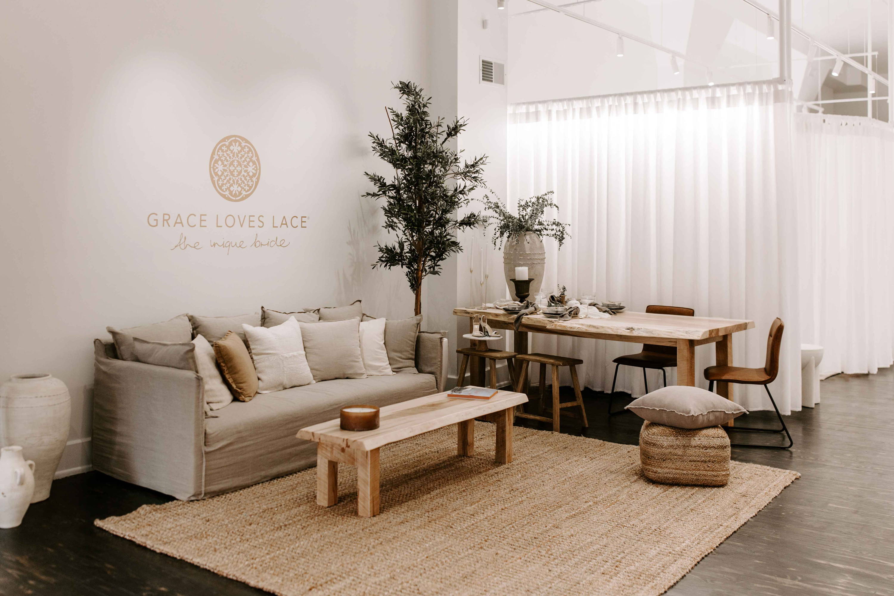 Showroom with beige couch and wooden tables and chairs