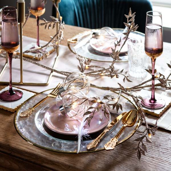 Pink and Gold Christmas decorations on a wooden dining table.