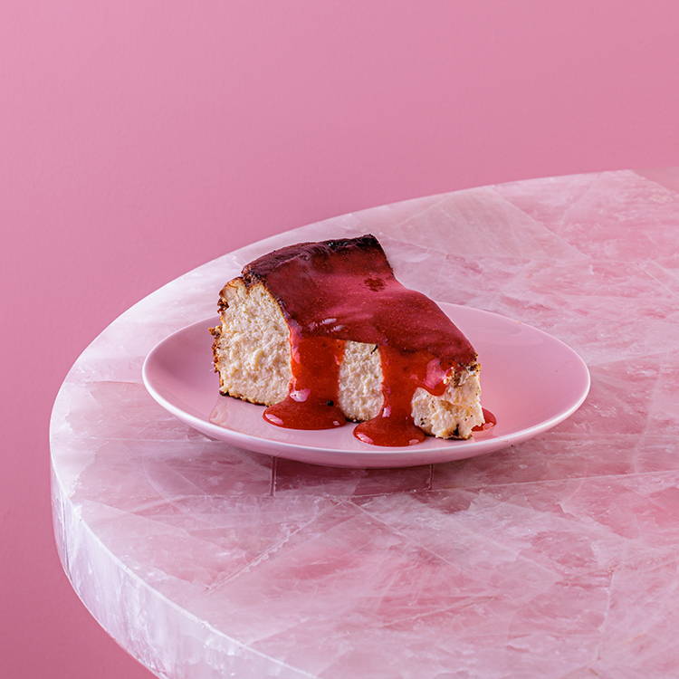San Sebastian Cheesecake slice with strawberry sauce on pink plate