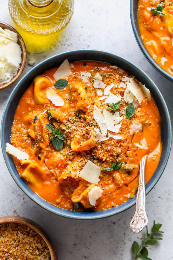 A tomato soup with cheese filled ravioli.