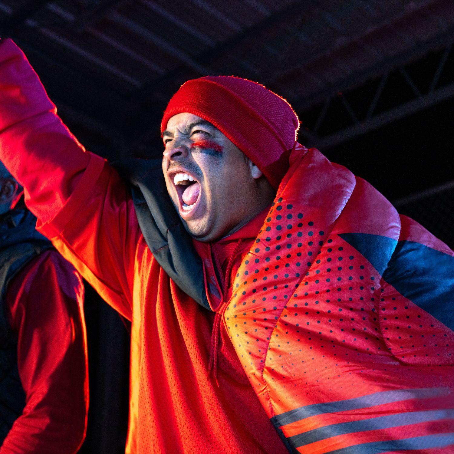 Person in vibrant red attire, celebrating with enthusiasm.