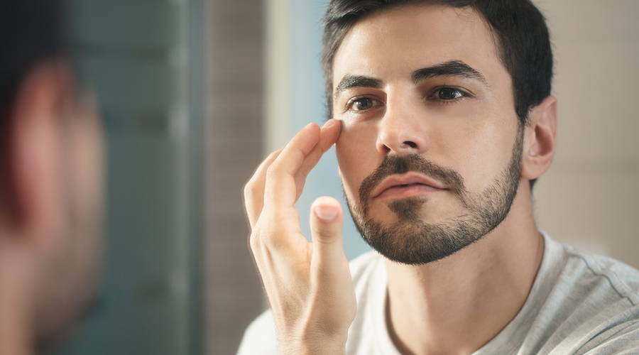man applying glycerin to undereyes
