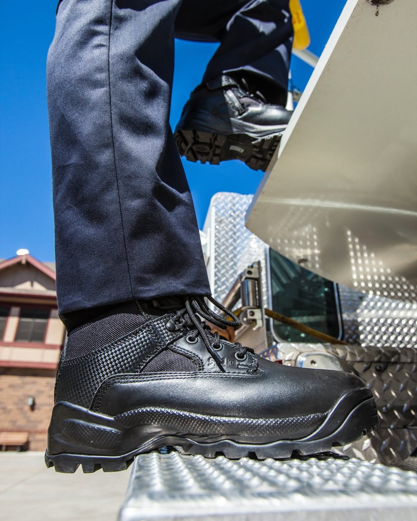 Person wearing black boots stepping onto a vehicle.