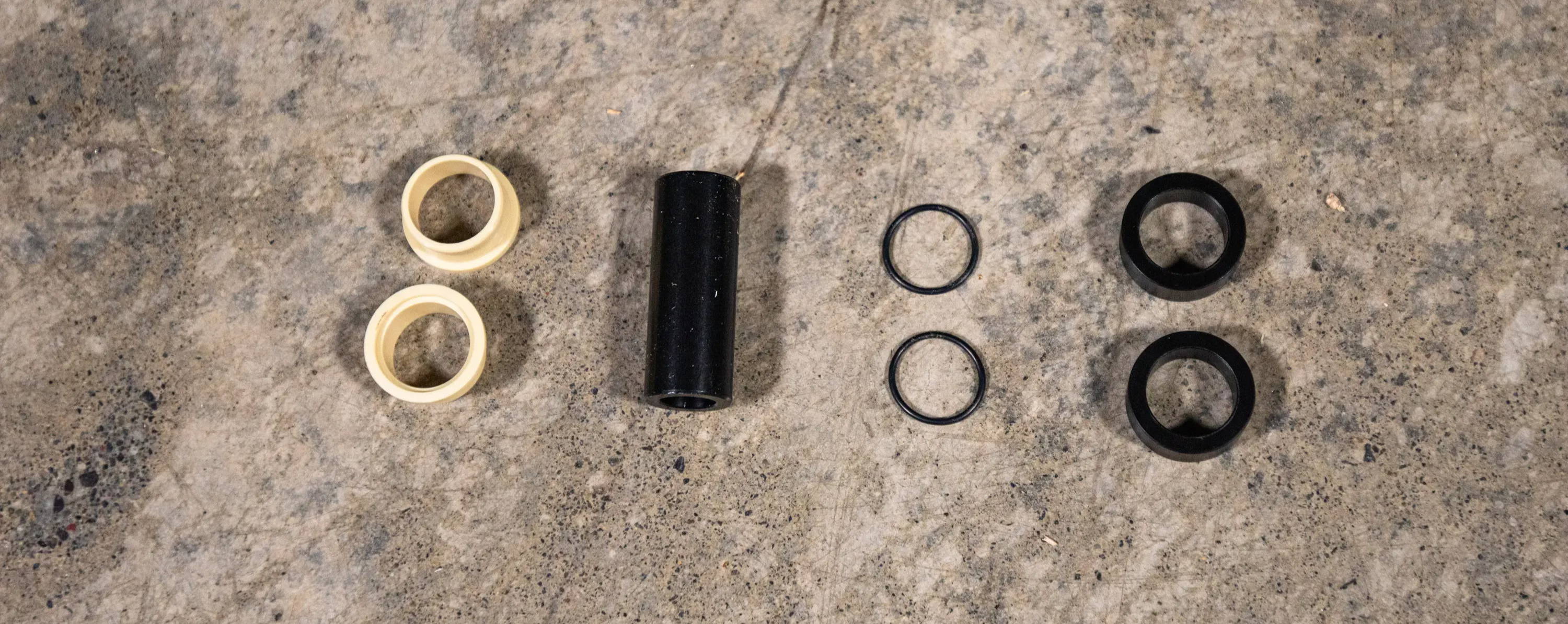 Mountain Bike Rear Shock Mounting hardware components layed out on the floor