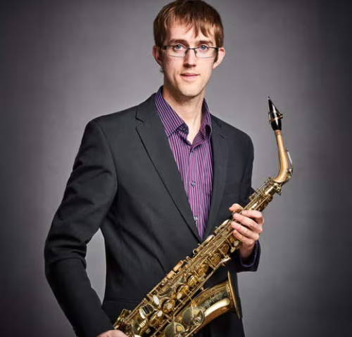 Alastair Penman holding alto saxophone