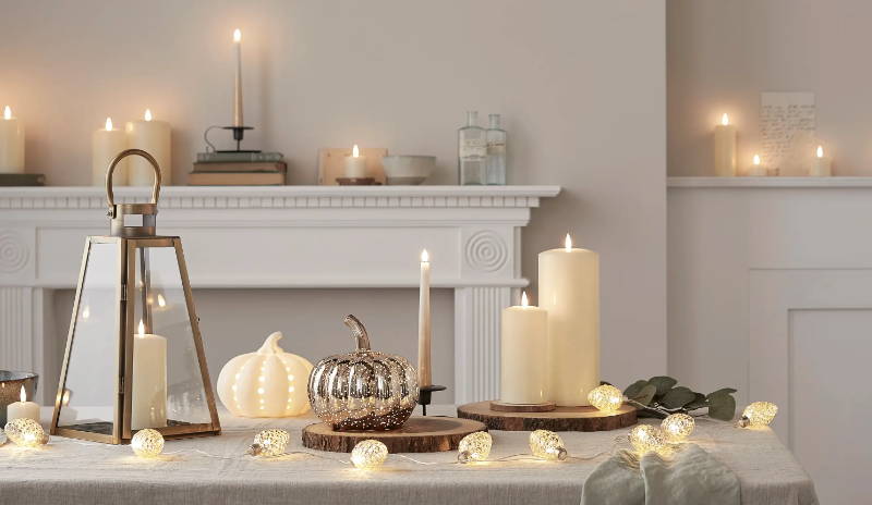 Autumnal table featuring TruGlow candles and pumpkin lights with pinecone fairy lights
