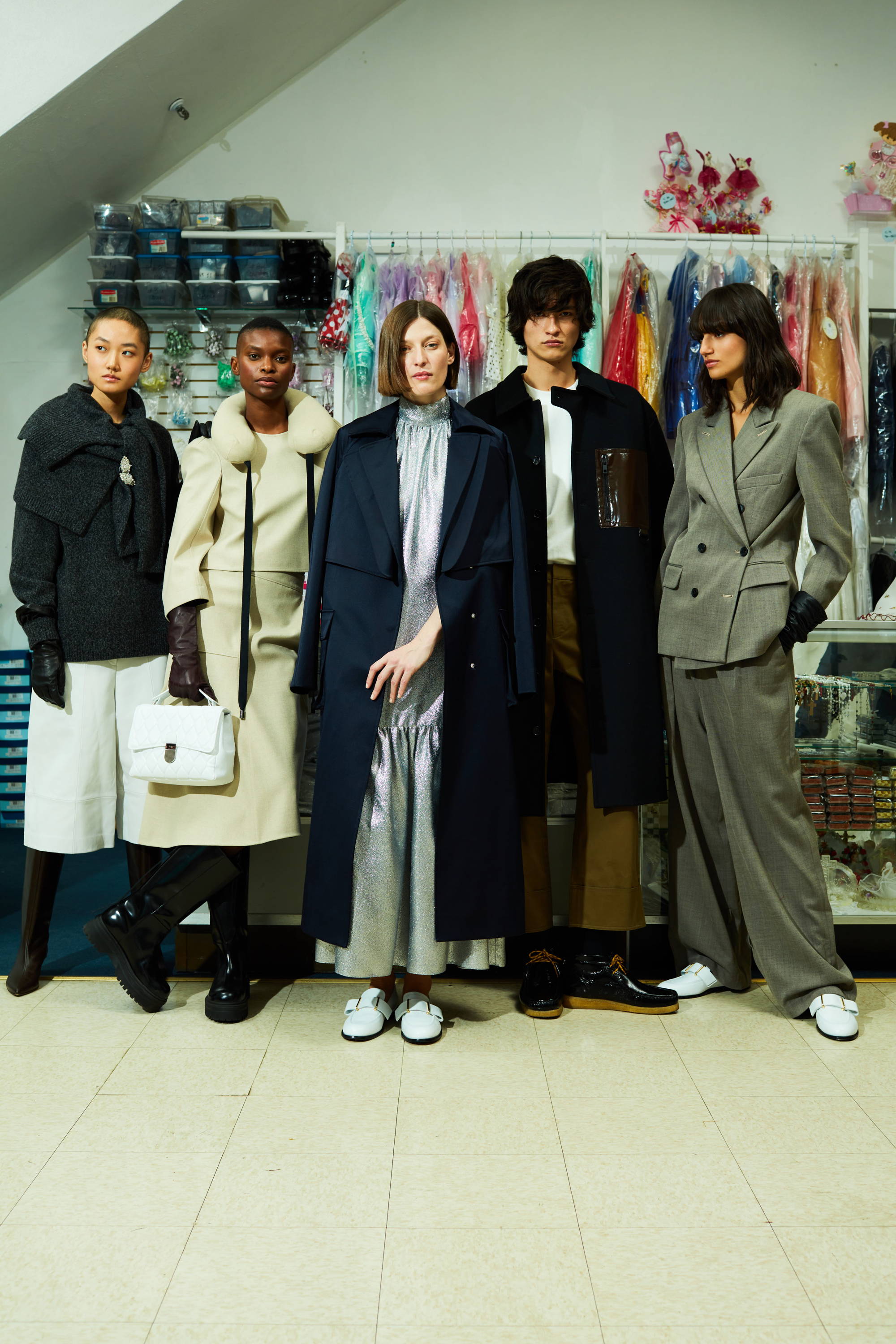 Five models showcasing stylish outfits against a colorful fabric background.