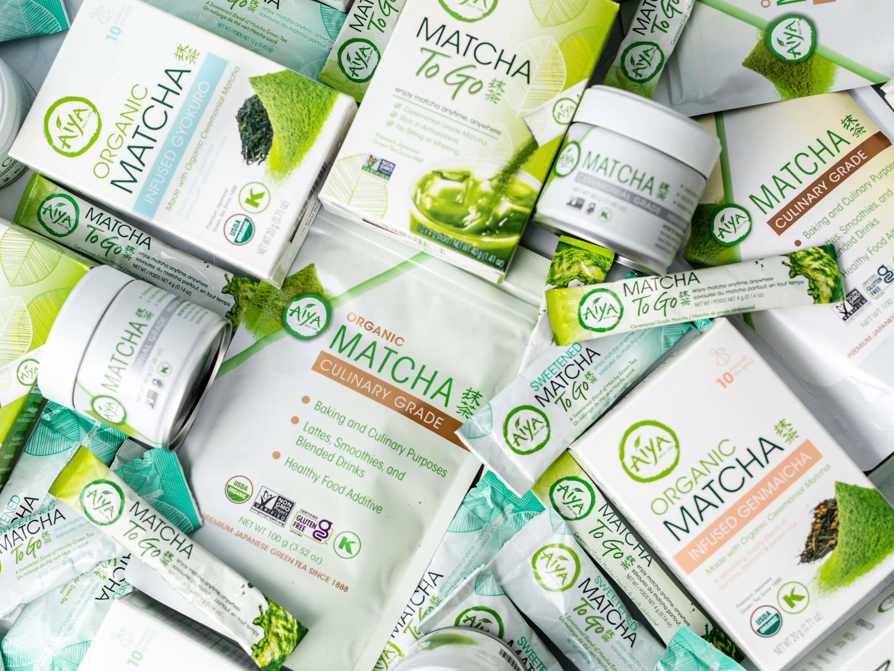 Various Aiya matcha product packaging arranged in a flat lay composition.