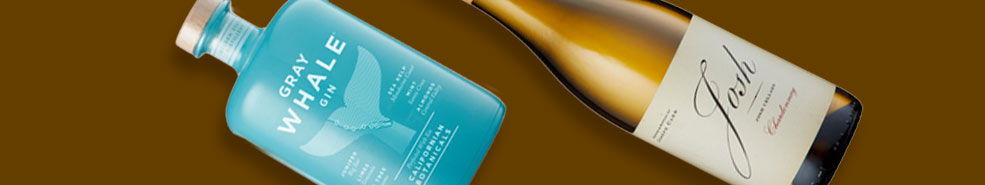 Two bottles of beverage, one blue and one gold, on a brown background.