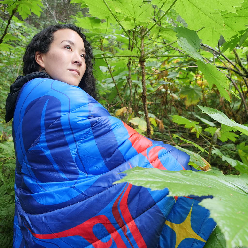 Crystal Worl wearing Rumpl blanket in forest