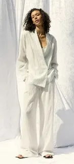 Model in white outfit against a white backdrop.