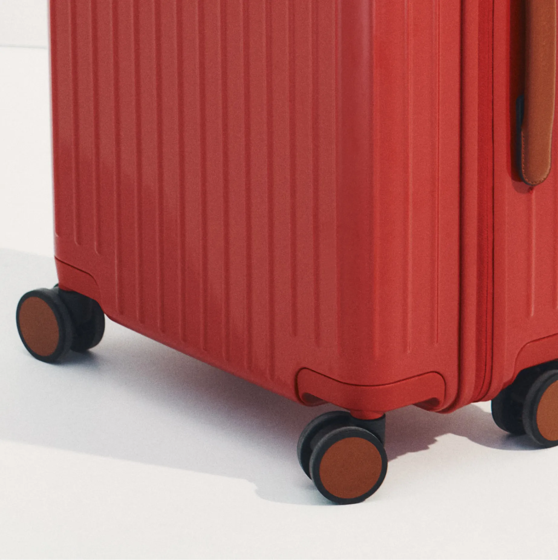 Red suitcase with wheels and textured surface.
