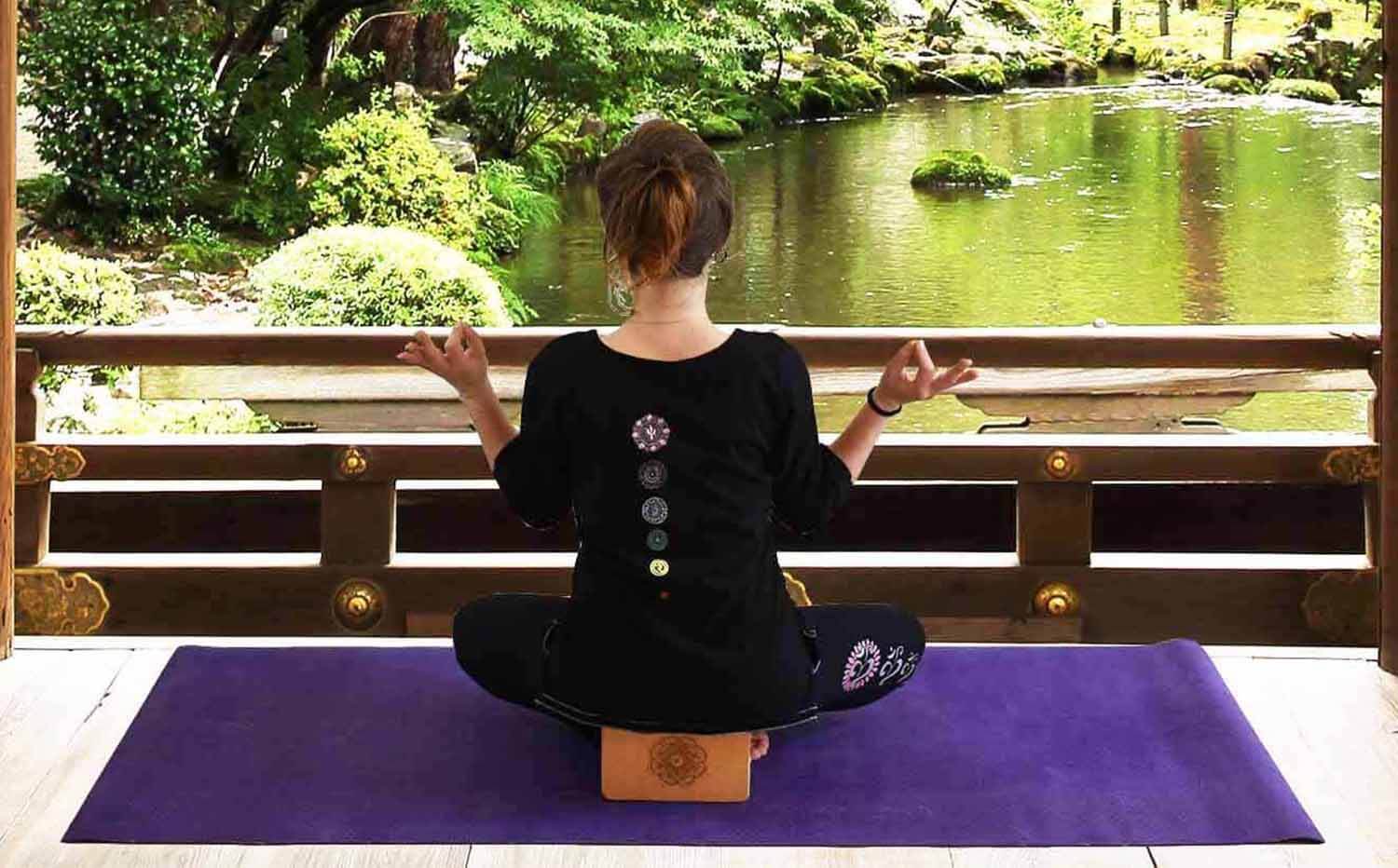 Magasin yoga Le havre - Yogini avec tee shirt yoga 7 chakras brodés qui médite dans un temple bouddhiste sur un tapis toile de jute - Achamana