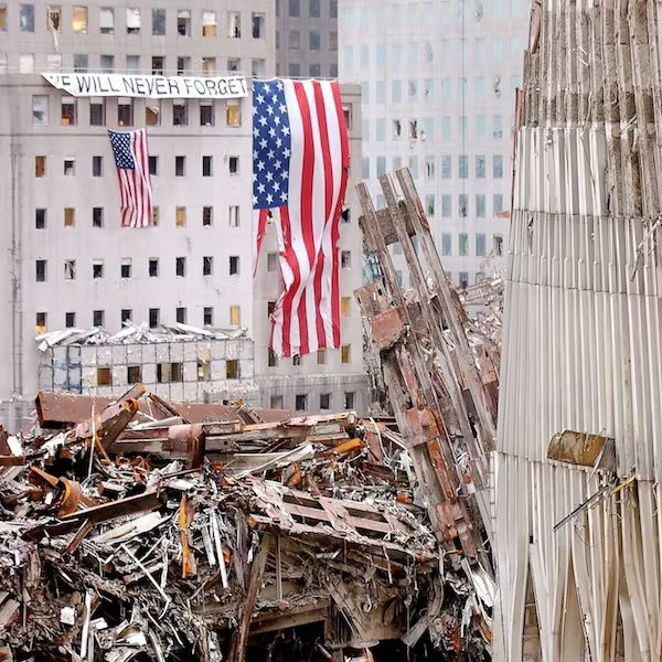 Destruction site with American flag and debris from collapsed buildings.