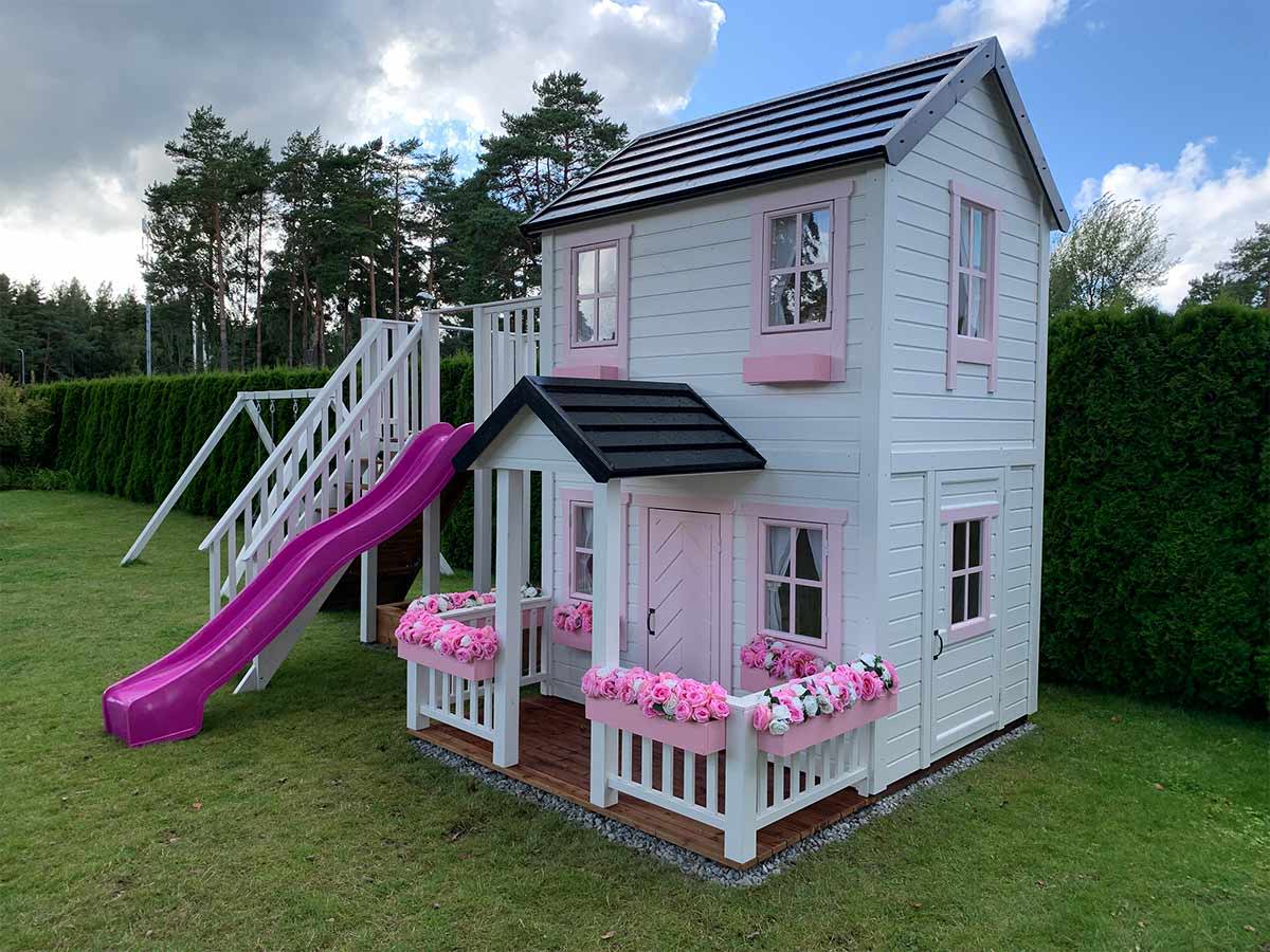 Outdoor playhouse in white with two levels, slide and flowers boxes in a backyard by WholeWoodPlayhouses