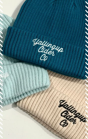 Flat lay of turquoise, seafoam and cream cord beanies with embroidered Yallingup Cider Co logo on the cuffs in seafoam and black thread