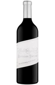 A bottle of red wine with a white label.