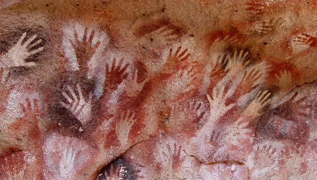 Cave art of humans stenciling hands