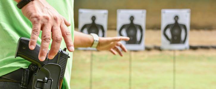 Man shooting silhouette targets at gun range