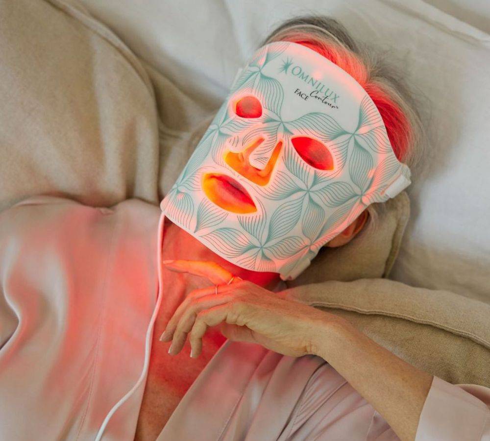 Woman wearing Omnilux LED light mask